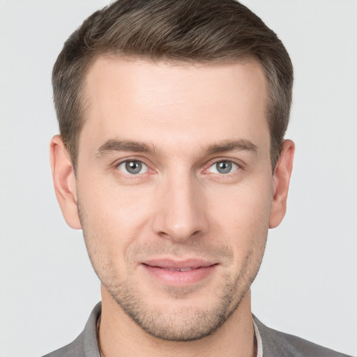 Joyful white young-adult male with short  brown hair and grey eyes