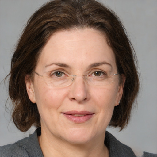 Joyful white adult female with medium  brown hair and grey eyes