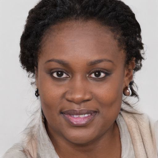 Joyful black young-adult female with long  brown hair and brown eyes
