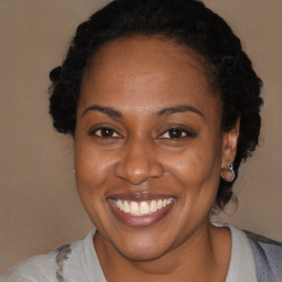 Joyful black adult female with medium  brown hair and brown eyes