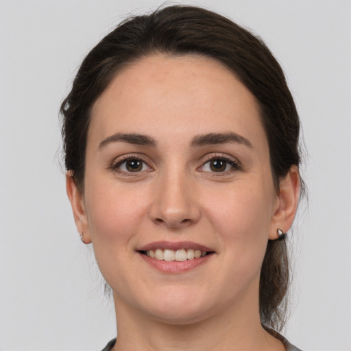 Joyful white young-adult female with medium  brown hair and brown eyes