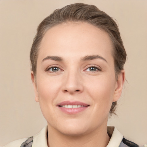 Joyful white young-adult female with medium  brown hair and grey eyes