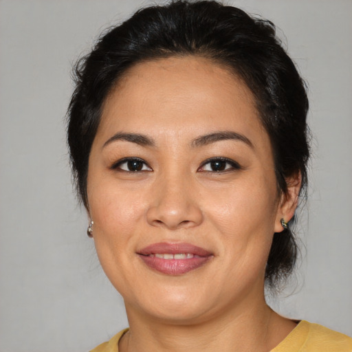 Joyful latino adult female with medium  brown hair and brown eyes