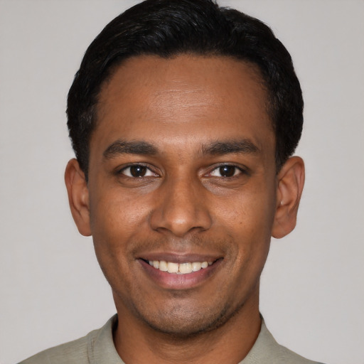 Joyful latino young-adult male with short  black hair and brown eyes