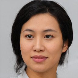 Joyful asian young-adult female with medium  brown hair and brown eyes