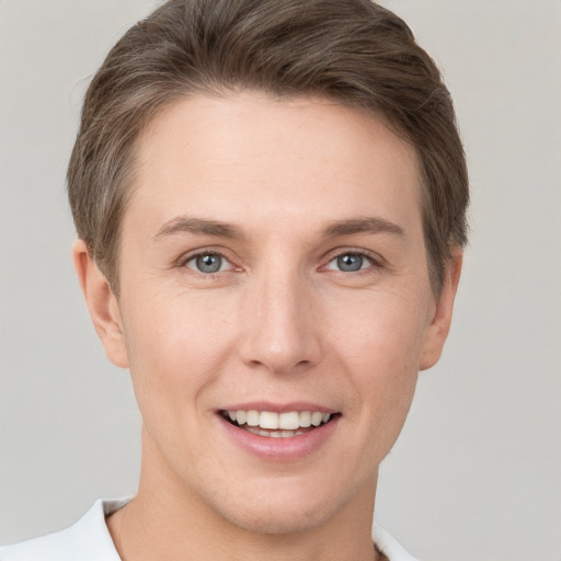 Joyful white young-adult female with short  brown hair and grey eyes