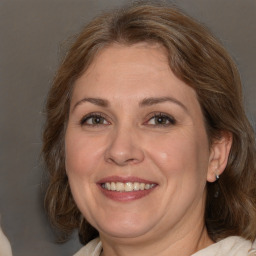 Joyful white adult female with medium  brown hair and blue eyes