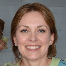 Joyful white adult female with medium  brown hair and blue eyes