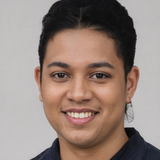 Joyful latino young-adult male with short  black hair and brown eyes