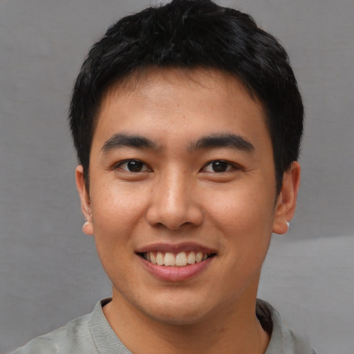 Joyful asian young-adult male with short  black hair and brown eyes