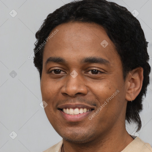 Joyful black young-adult male with short  black hair and brown eyes