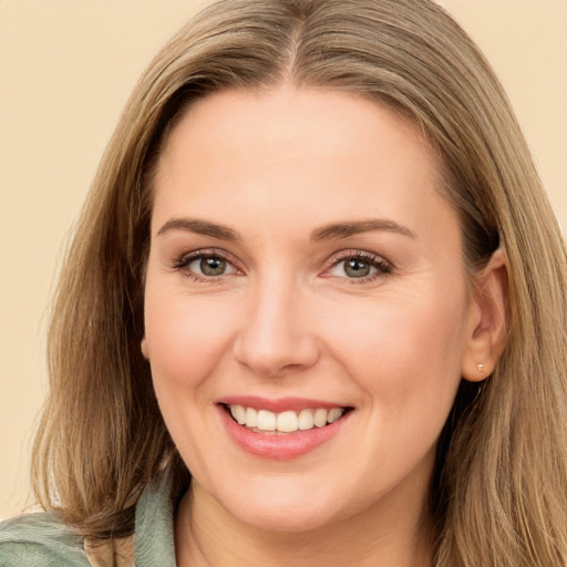 Joyful white young-adult female with long  brown hair and green eyes