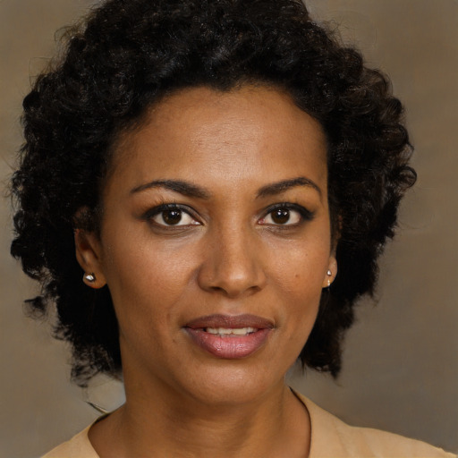 Joyful black young-adult female with long  brown hair and brown eyes