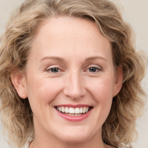 Joyful white young-adult female with medium  brown hair and blue eyes