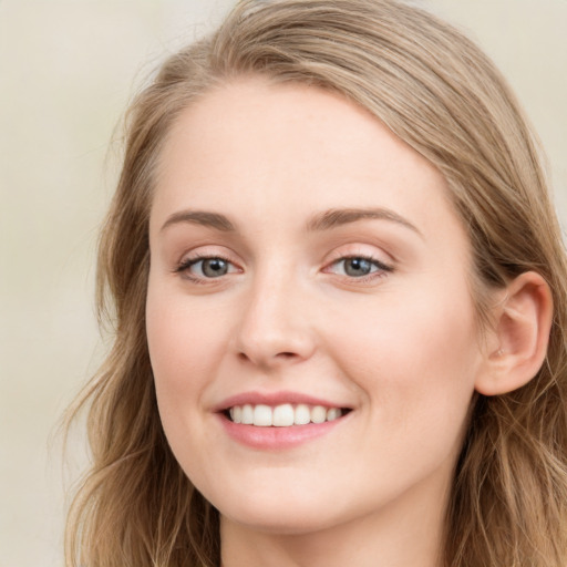 Joyful white young-adult female with long  brown hair and blue eyes