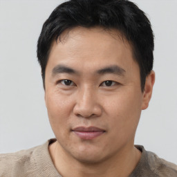 Joyful asian young-adult male with short  black hair and brown eyes
