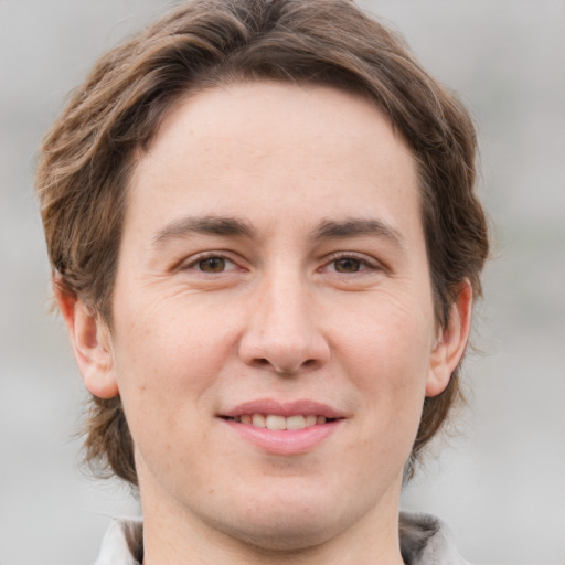 Joyful white young-adult male with medium  brown hair and grey eyes