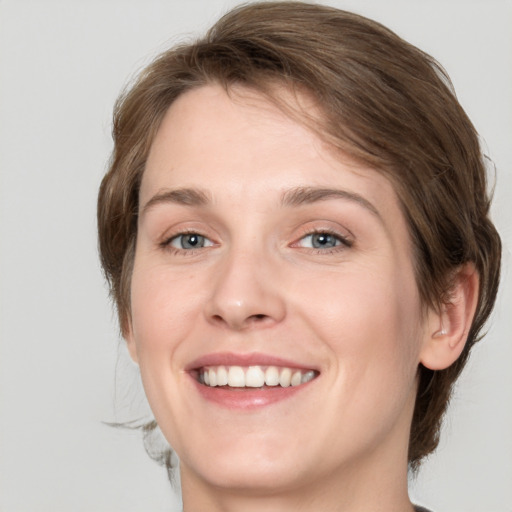 Joyful white young-adult female with medium  brown hair and green eyes