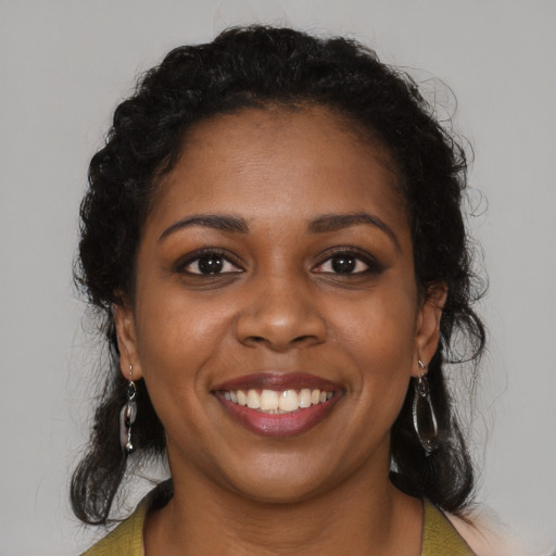 Joyful black young-adult female with long  brown hair and brown eyes