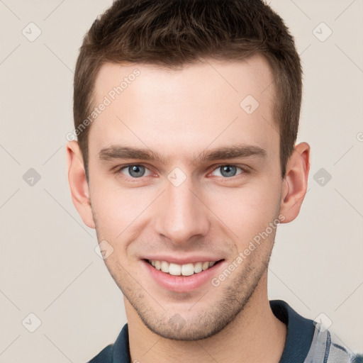 Joyful white young-adult male with short  brown hair and grey eyes