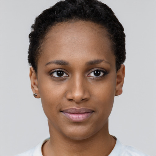 Joyful black young-adult female with short  black hair and brown eyes