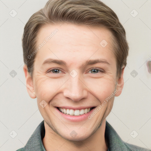 Joyful white young-adult male with short  brown hair and grey eyes