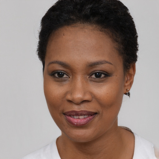 Joyful black young-adult female with short  black hair and brown eyes