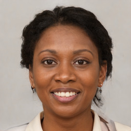 Joyful black adult female with medium  brown hair and brown eyes