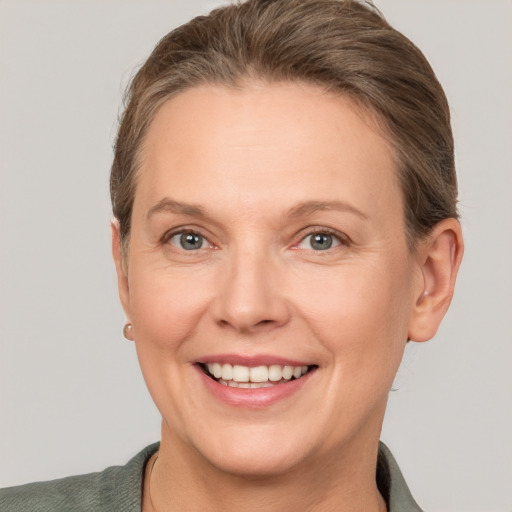 Joyful white adult female with short  brown hair and grey eyes