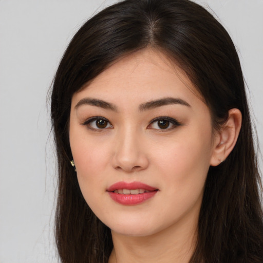 Joyful asian young-adult female with long  brown hair and brown eyes