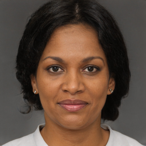 Joyful black adult female with short  brown hair and brown eyes