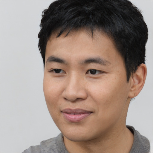Joyful asian young-adult male with short  black hair and brown eyes