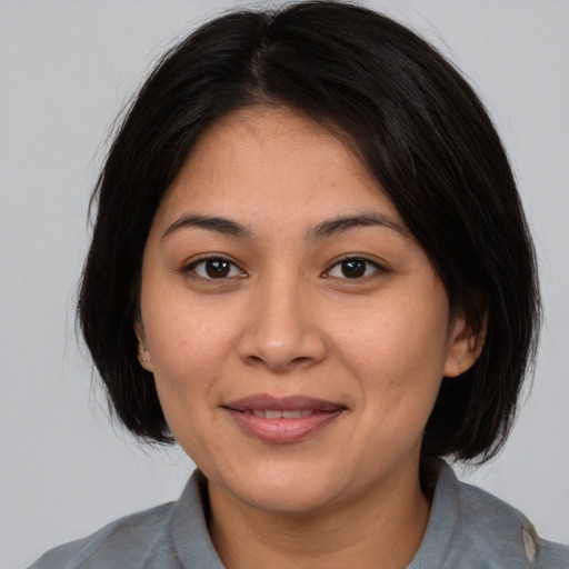 Joyful latino young-adult female with medium  brown hair and brown eyes