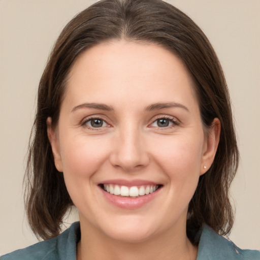 Joyful white young-adult female with medium  brown hair and grey eyes