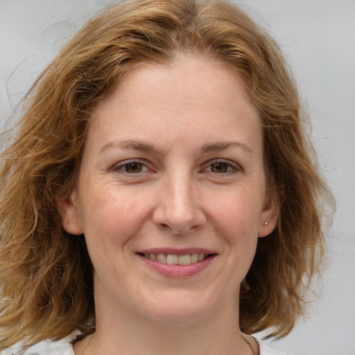 Joyful white young-adult female with medium  brown hair and blue eyes