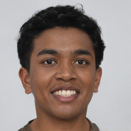 Joyful black young-adult male with short  black hair and brown eyes