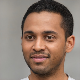 Joyful black young-adult male with short  black hair and brown eyes