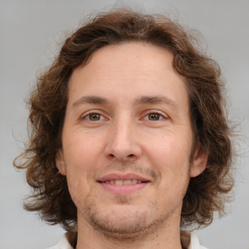 Joyful white adult male with medium  brown hair and brown eyes