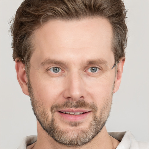 Joyful white adult male with short  brown hair and grey eyes