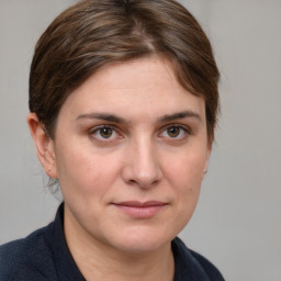 Joyful white young-adult female with medium  brown hair and grey eyes