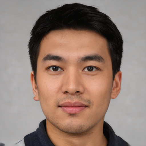 Joyful asian young-adult male with short  black hair and brown eyes