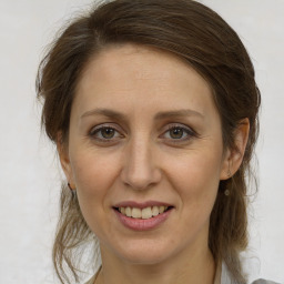 Joyful white adult female with medium  brown hair and grey eyes