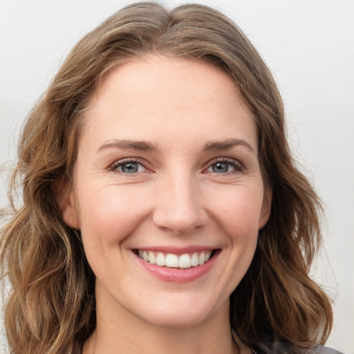 Joyful white young-adult female with medium  brown hair and green eyes