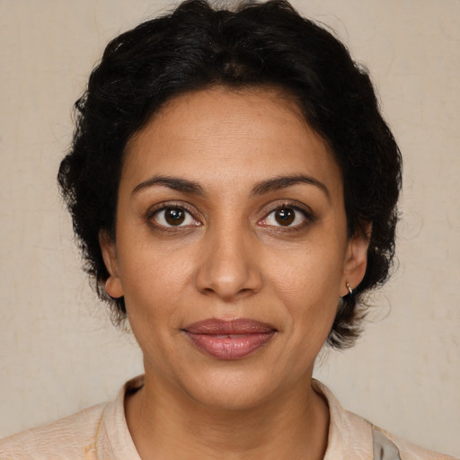 Joyful latino adult female with medium  brown hair and brown eyes