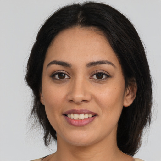 Joyful latino young-adult female with medium  brown hair and brown eyes