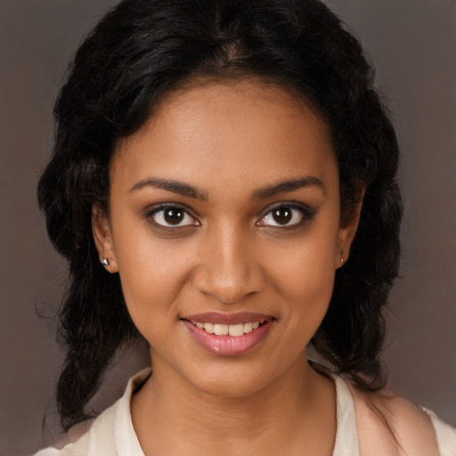 Joyful black young-adult female with long  brown hair and brown eyes