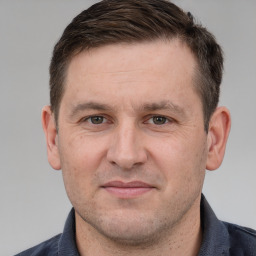 Joyful white adult male with short  brown hair and grey eyes