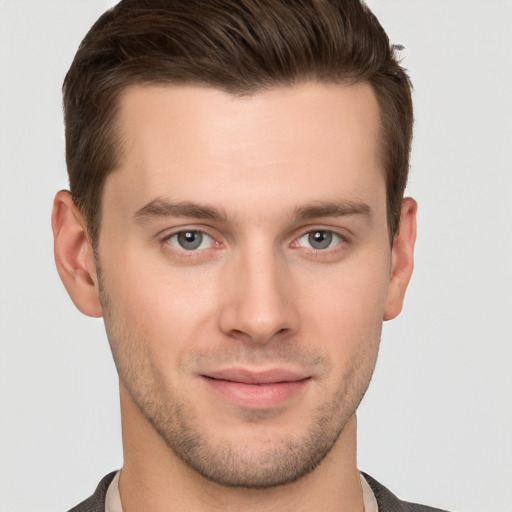 Joyful white young-adult male with short  brown hair and grey eyes