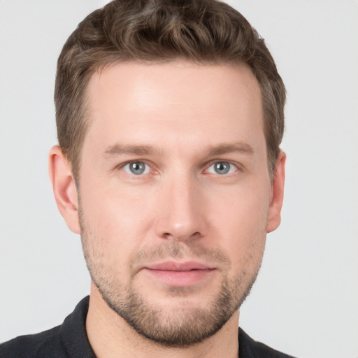 Joyful white young-adult male with short  brown hair and grey eyes