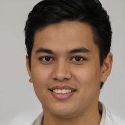 Joyful latino young-adult male with short  brown hair and brown eyes